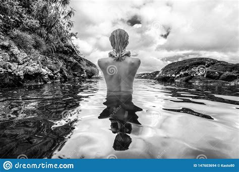 donna nuda che bagna e che si rilassa nella piscina naturale in bianco e nero fotografia stock