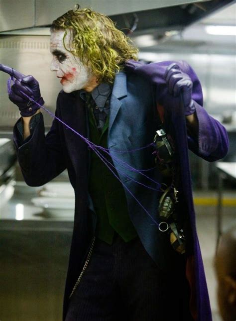 The Joker Is Dressed In Purple And Holding His Hands Up With One Hand