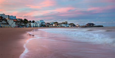 Viking Bay in Broadstairs, Kent at sunset with town lit up in the 