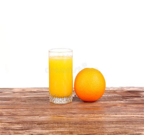 Glass Of Freshly Pressed Orange Juice With Sliced Orange Half On Wooden