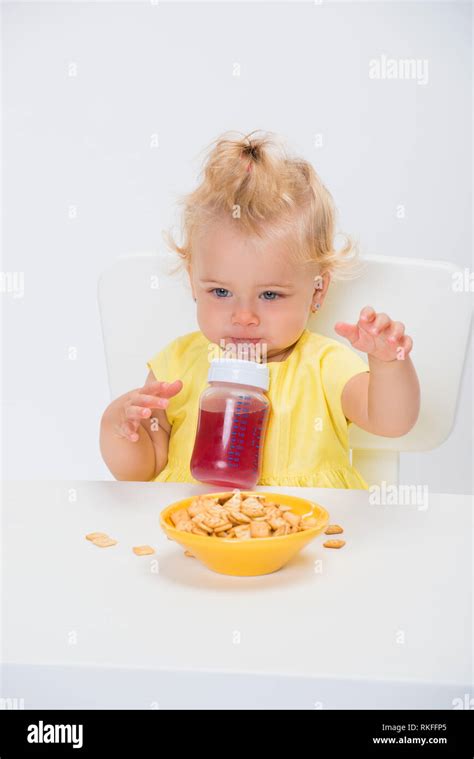 Cute Little Baby Girl 1 Year Old Eating Cereal Flakes And Drinking