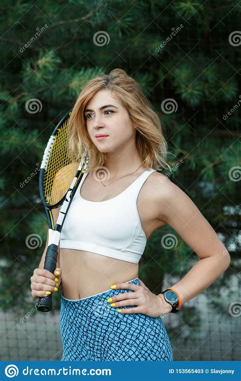 Beautiful Young Girl In Sportswear Holding A Tennis Racket In His Hands