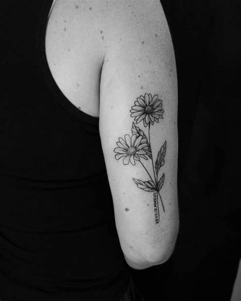 A Woman With A Flower Tattoo On Her Arm