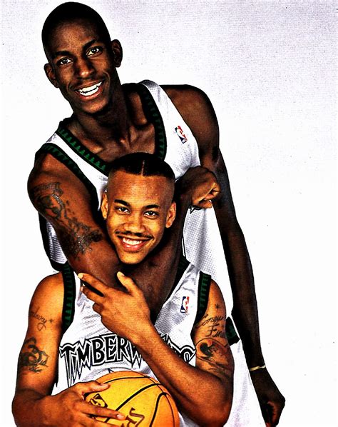 Two Basketball Players Hugging Each Other With Tattoos On Their Arms And Chest Both Holding A