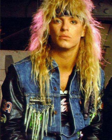 A Man With Long Blonde Hair Wearing A Denim Jacket And Fringes On His Head