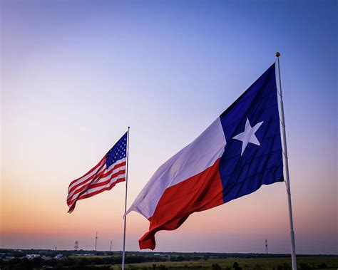 Texas And American Flags Waving Above The Texas Countrside Photograph