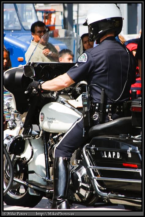 A Police Officer Riding On The Back Of A Motorcycle