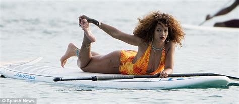 Rihanna Showcases Her Curves In A Flame Coloured Swimsuit As She Paddle Boards In Barbados