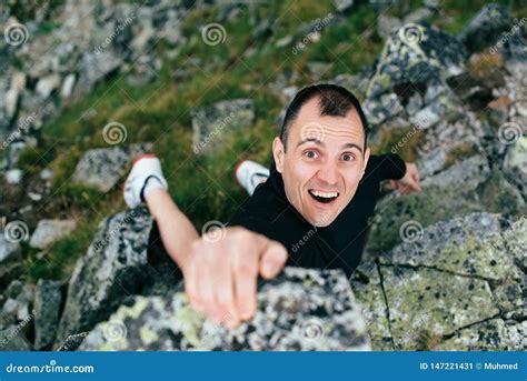 Young Man Climbing A Steep Wall In Mountain Rock Climb Extreme Sport