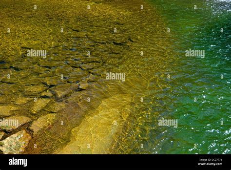 Shimmering Water Surface In A Shallow Area Fortified With Stones