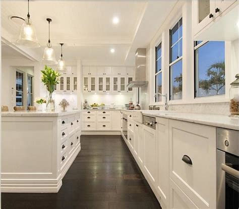 Dark wood floors and a white kitchen island with marble countertops create a rich and relaxing experience. Yay or Nay - Dark wooden kitchen floor