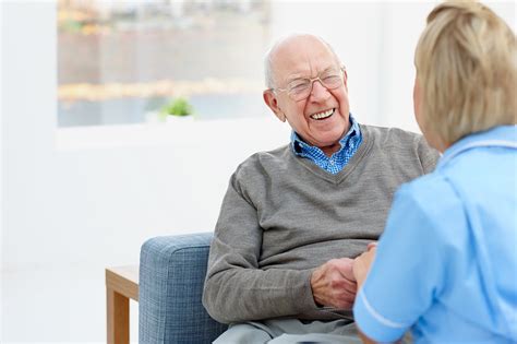 Happy Elderly Patient Talking With Nurse At Home Glasgow Memory Clinic