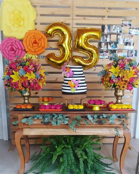 A Decorated Table With Flowers And Balloons For A 35th Birthday Or