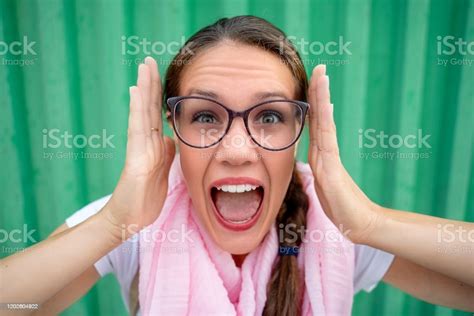 Stressed Young Woman Screaming And Looking At Camera Against Green