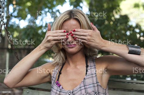Blond Woman Outdoors Holding Her Hands Over Her Eyes Stock Photo