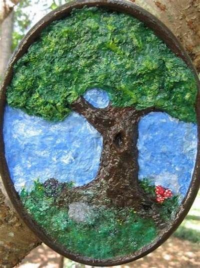 A Tree Is Painted On The Side Of A Metal Circle Hanging From A Tree Trunk