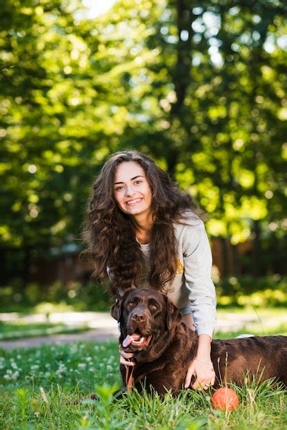 Free Photo Portrait Of A Happy Young Woman And Her Dog In Garden