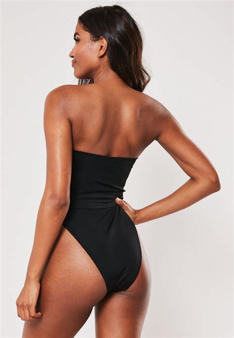 A Black Bandeau Swimsuit With A Separate Silver Waist Belt