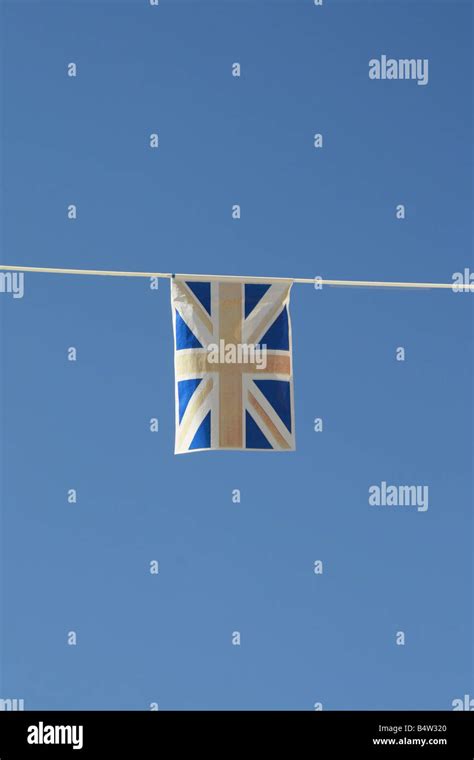 Old Faded Union Jack Flag Flying In Wind In Sun Stock Photo Alamy