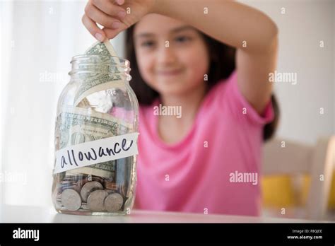 Girl Saving Allowance In Money Jar Stock Photo Alamy