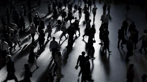 Silhouette of crowds of people walking on public city street shot in