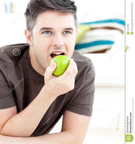 Cheerful beautiful man eating apple isolated stock image. Young Man Lying On The Floor And Eating An Apple Stock ...