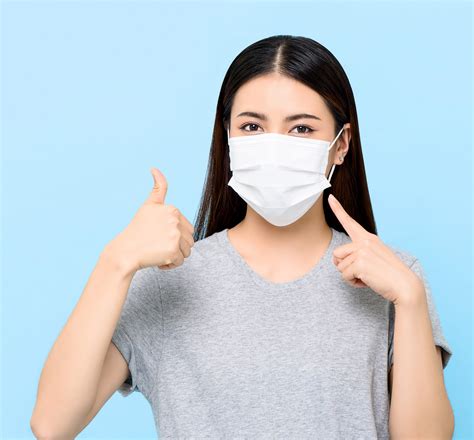 Young Asian Woman Wearing Face Mask To Protect From Covid 19 And Giving
