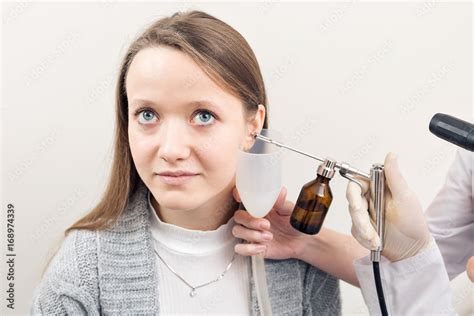 Ent Physician Looking Into Patients Ear With An Instrument Private