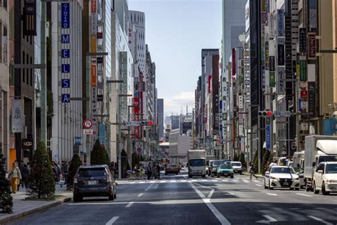 una calle en una ciudad japonesa con un denso edificio de casas altas y modernas y autos que
