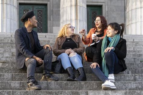 Multi Ethnic Group Of Friends Sitting On Some Stairs Stock Photo