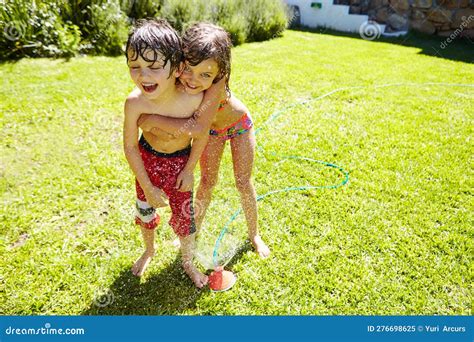 youre the best brother ever a brother and sister having fun with a sprinkler in the backyard