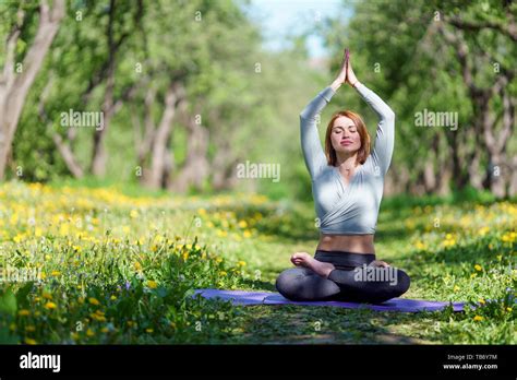 Foto De Mujer Haciendo Yoga Con Los Brazos Levantados Sentado En Posición De Loto Sobre La