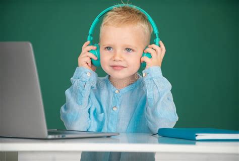 Cute Boy Wearing Headphones Study With Laptop In Classroom Listening
