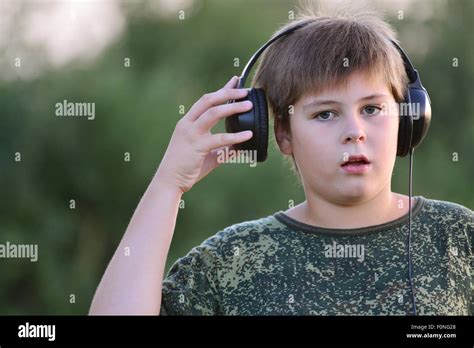 Boy Teenager Listening To Music With Headphones On Nature Stock Photo