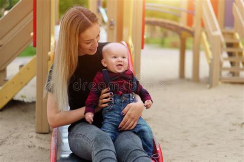 Beautiful Young Mother Walks With Her Little Son In A Summer Park Stock