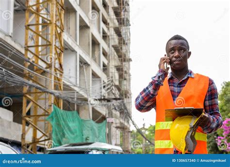 Thoughtful Young Black African Man Construction Worker Talking O Stock