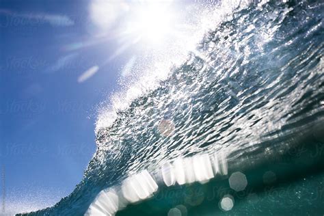 A Breaking Wave Backlit By The Bright Sun By Stocksy Contributor