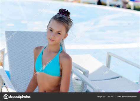junges mädchen im badeanzug auf einem regal am pool stockfotografie lizenzfreie fotos