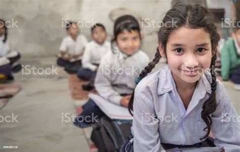 School Girl In Uniform Of Indian Ethnicity Sitting In Their Village