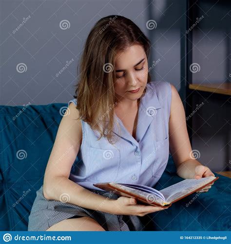 Young Woman Sits And Relax On The Couch And Looks In Her Diary Stock Image Image Of Lady