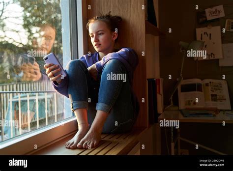 Mädchen Das Barfuß Auf Der Fensterbank Am Abend Sitzt Und Smartphone