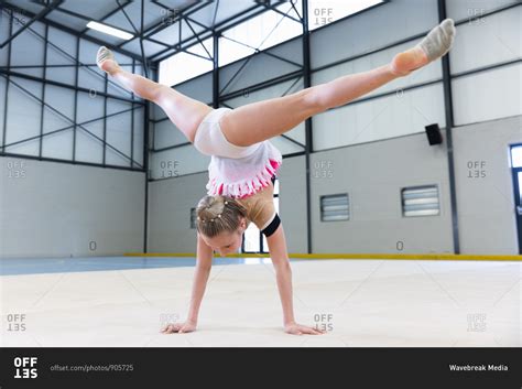 Rear View Of Teenage Caucasian Female Gymnast Performing At Sports Hall Doing Handstand And