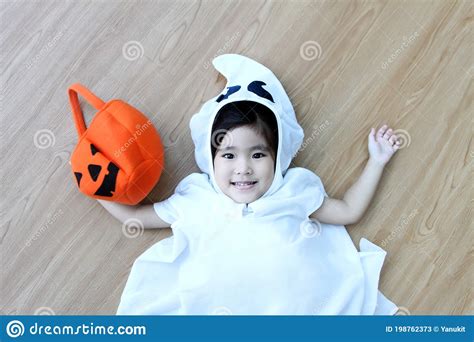 Happy Hallooween Asian Kid In Ghost Costum On Red Isolated Background
