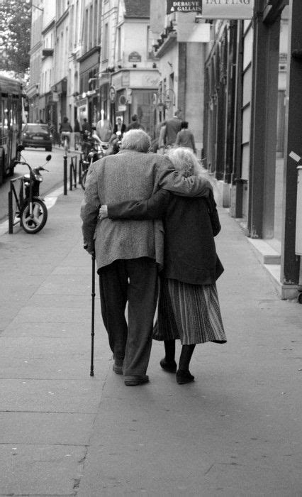 Elderly Couple Walking With Arms Around Each Other As Seen From Behind