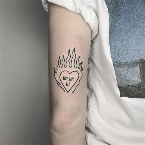 A Womans Arm With A Tattoo That Reads The Love Is In Flames