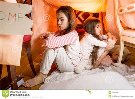 Dos Hermanas Resentidas Que Se Sientan En Piso En El Dormitorio De