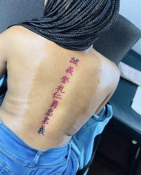 The Back Of A Womans Body With Chinese Writing On Her Left Side Ribcage