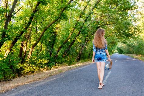 Beautiful Girl Walking On Empty Road Between Green Trees Stock Image