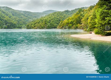 View Of Lake With Turquoise Water With Sand Island With Trees Stock