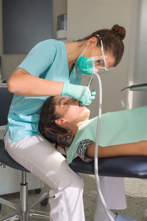 orthodontist curing her patient using dental drill by stocksy contributor ibex media stocksy